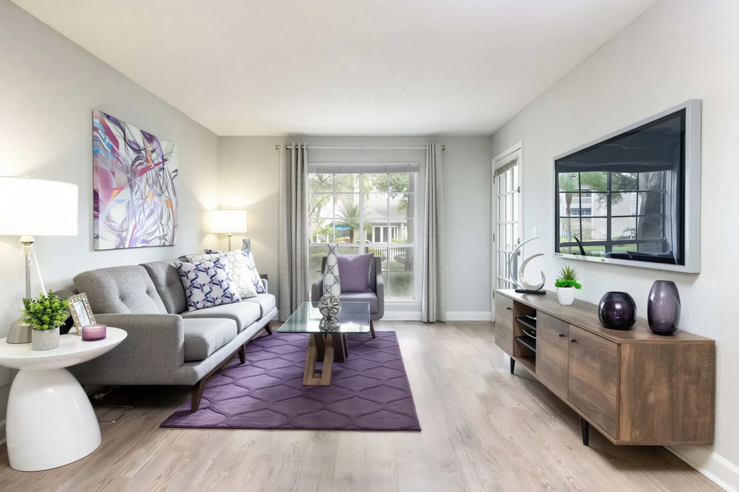 Renovated apartment living room with wood-style flooring at Arbour Ponds in Tampa, FL
