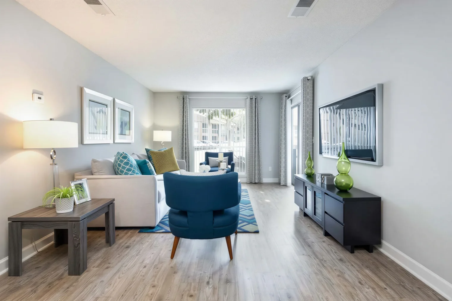 Spacious living room with wood-style flooring and courtyard views at Arbour Ponds in Tampa