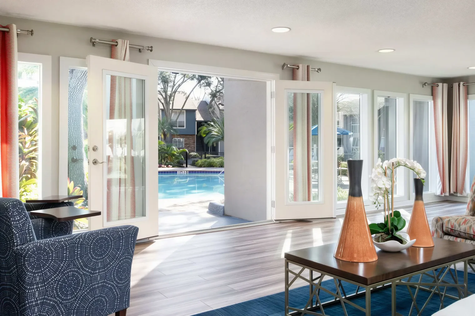 Bright resident clubhouse lounge overlooking the pool at Arbour Ponds Apartments in Tampa